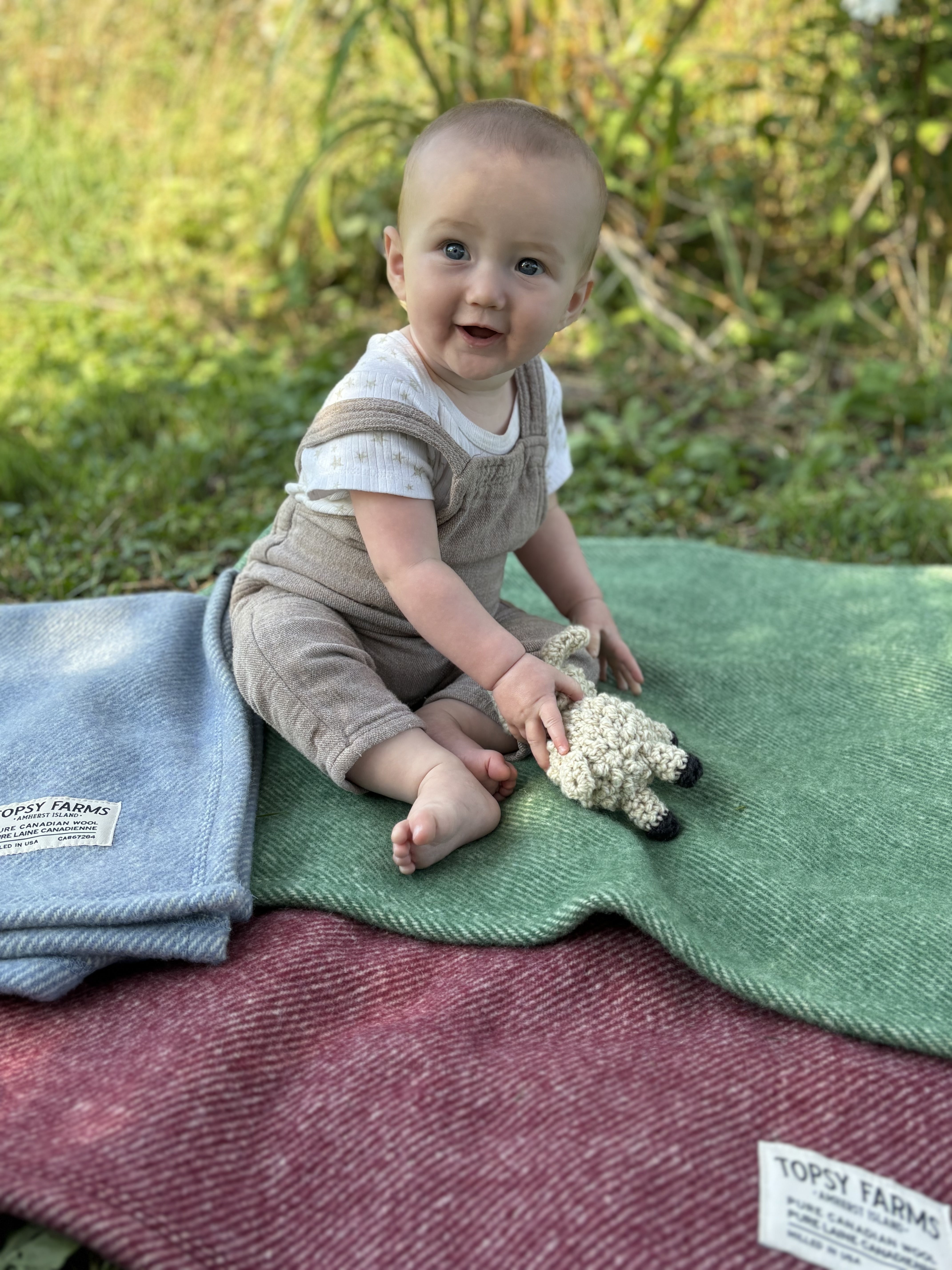 Smiling baby on Topsy Farms' Canadian wool baby blankets