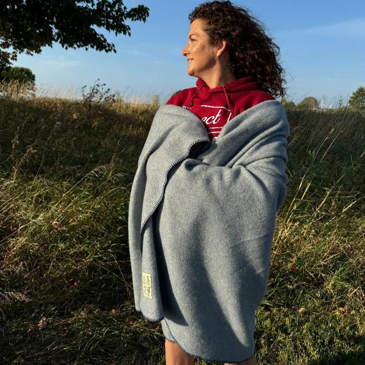 Topsy Farms' Canadian wool throw wrapped around a woman in a field